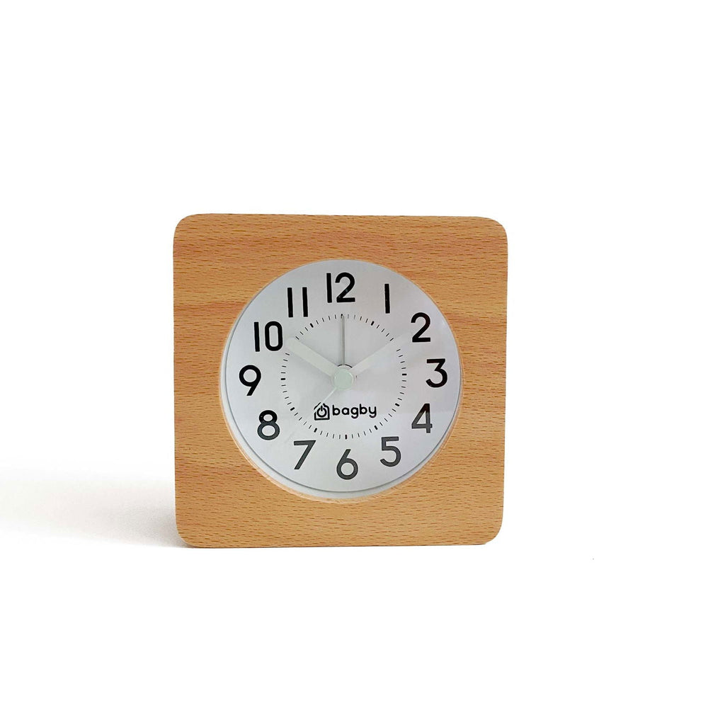 Square clock with wooden frame and white face on plain white surface indoors