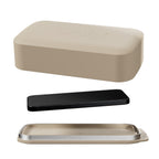 Beige case on white surface with black phone and metallic tray below in minimalistic setting