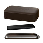 Three rounded rectangular objects in dark brown, black, and brown-silver on white surface