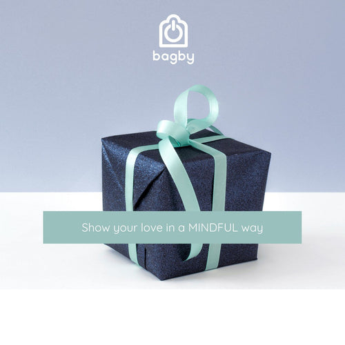 Dark blue gift box with a shiny surface and a light teal ribbon bow on a white surface