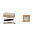 Beige container with lid and black object inside on white surface in uncluttered environment