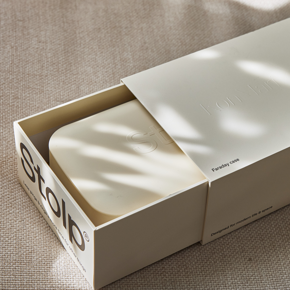 The Stolp x KonMari box partially slid open out of its packaging sleeve on linen